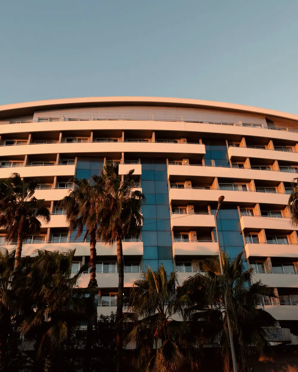 Hotel building with palm trees glowing in golden sunset light