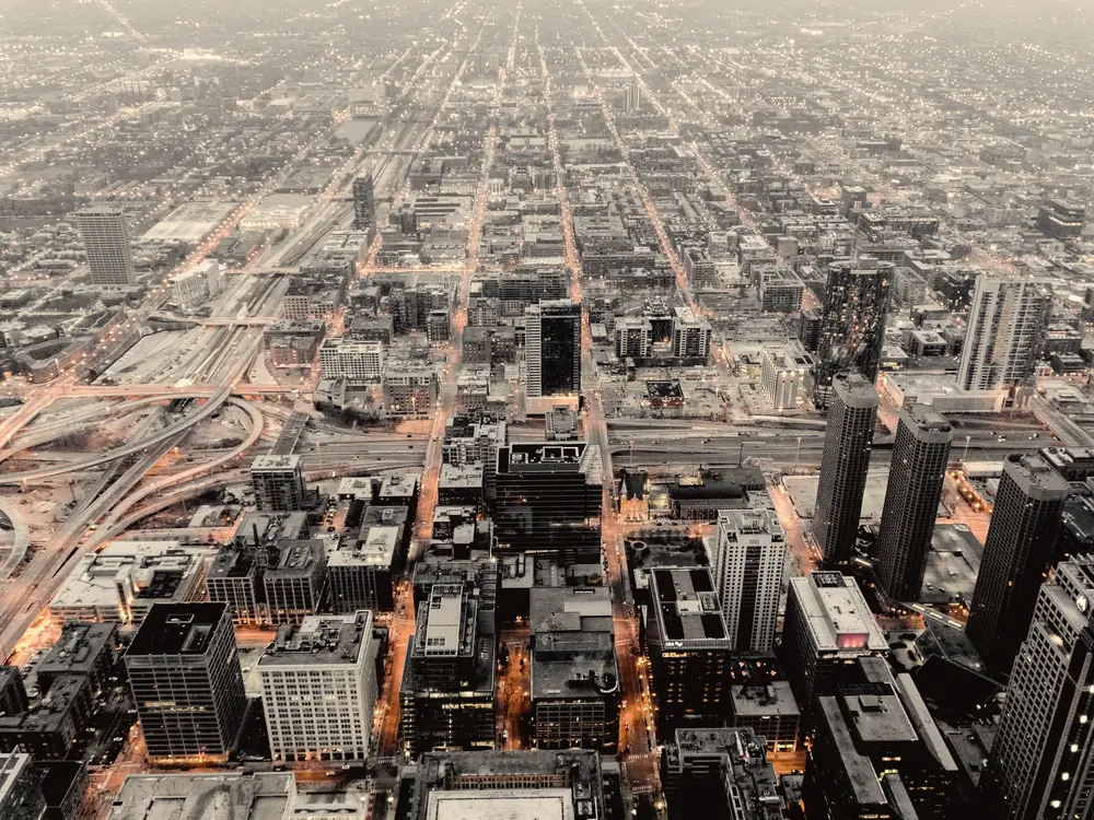 Aerial view of a city grid with towers and highways at dusk