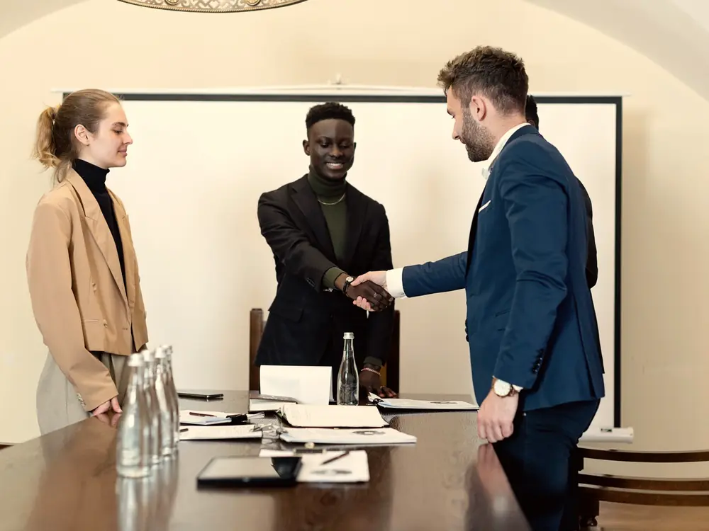 Business professionals shaking hands after a meeting in a conference room
